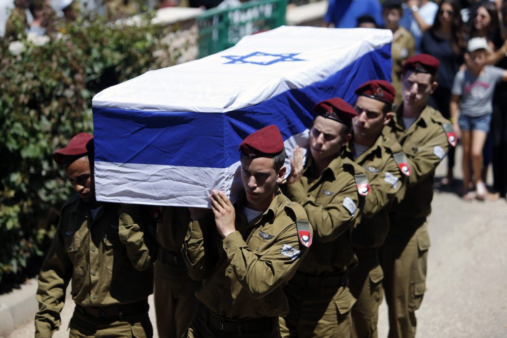 Israeli soldiers carry the flag-draped coffin of their comrade Guy Algranati during his funeral in Tel Aviv